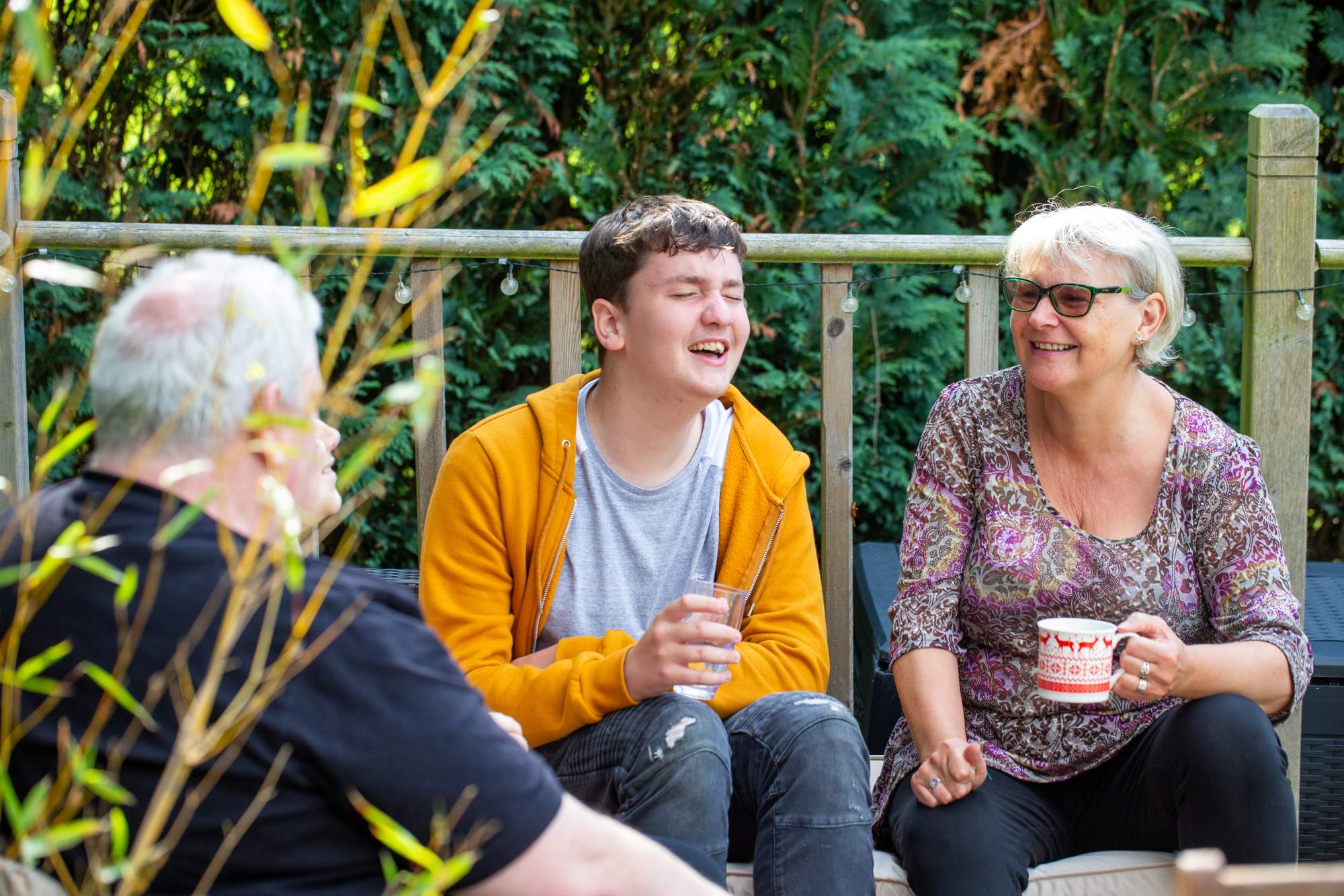 A teenage boy laughing with his parents
